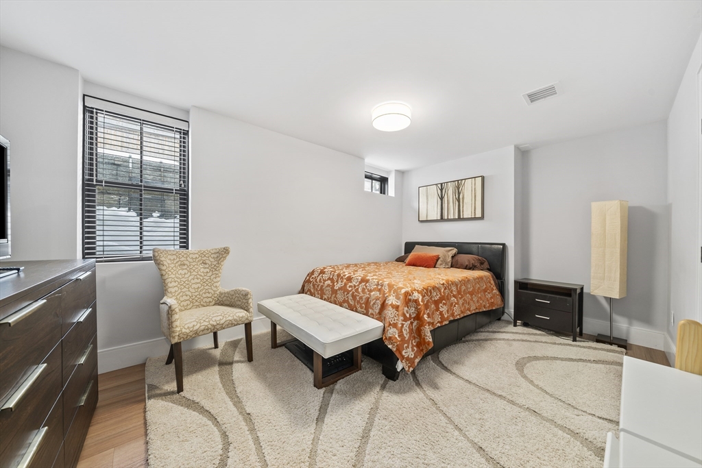 300 Elliot Street, Unit 2 Newton, MA 02464 - Photo 33 of 42 a bedroom with a bed and wooden floor