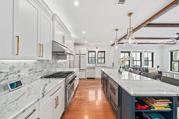 a large white kitchen with sink and dishwasher