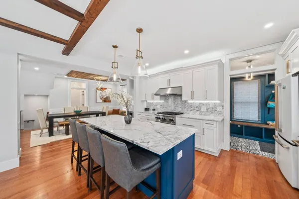 a kitchen with stainless steel appliances granite countertop a kitchen island a stove a table and chairs in it