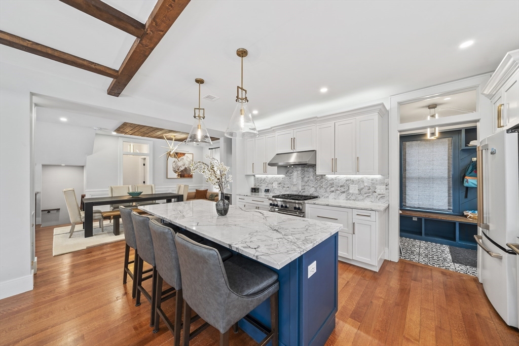 300 Elliot Street, Unit 2 Newton, MA 02464 - Photo 5 of 42 a kitchen with stainless steel appliances granite countertop a kitchen island a stove a table and chairs in it
