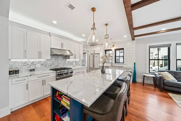 a large kitchen with kitchen island a stove a sink a dining table and chairs