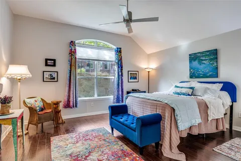 a spacious bedroom with a bed a table and chair