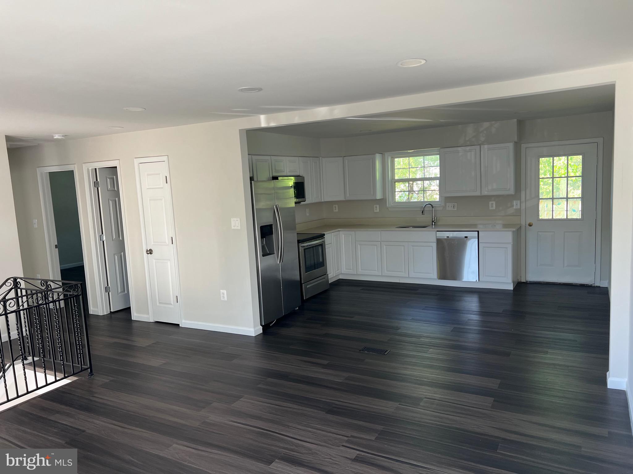 6604 Suitland Road Suitland, MD 20746 - Photo 14 of 27 an empty room with wooden floor and a kitchen