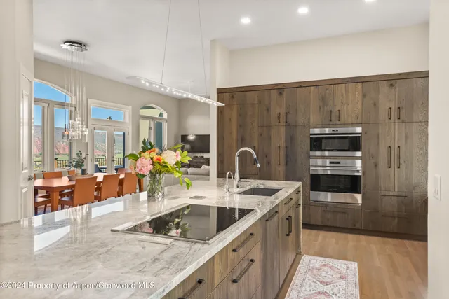 a kitchen with stainless steel appliances kitchen island granite countertop a sink and refrigerator