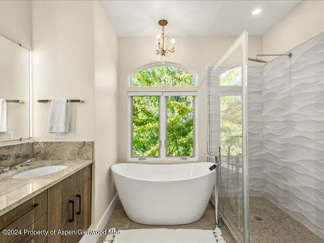 a bathroom with a granite countertop sink and a bathtub