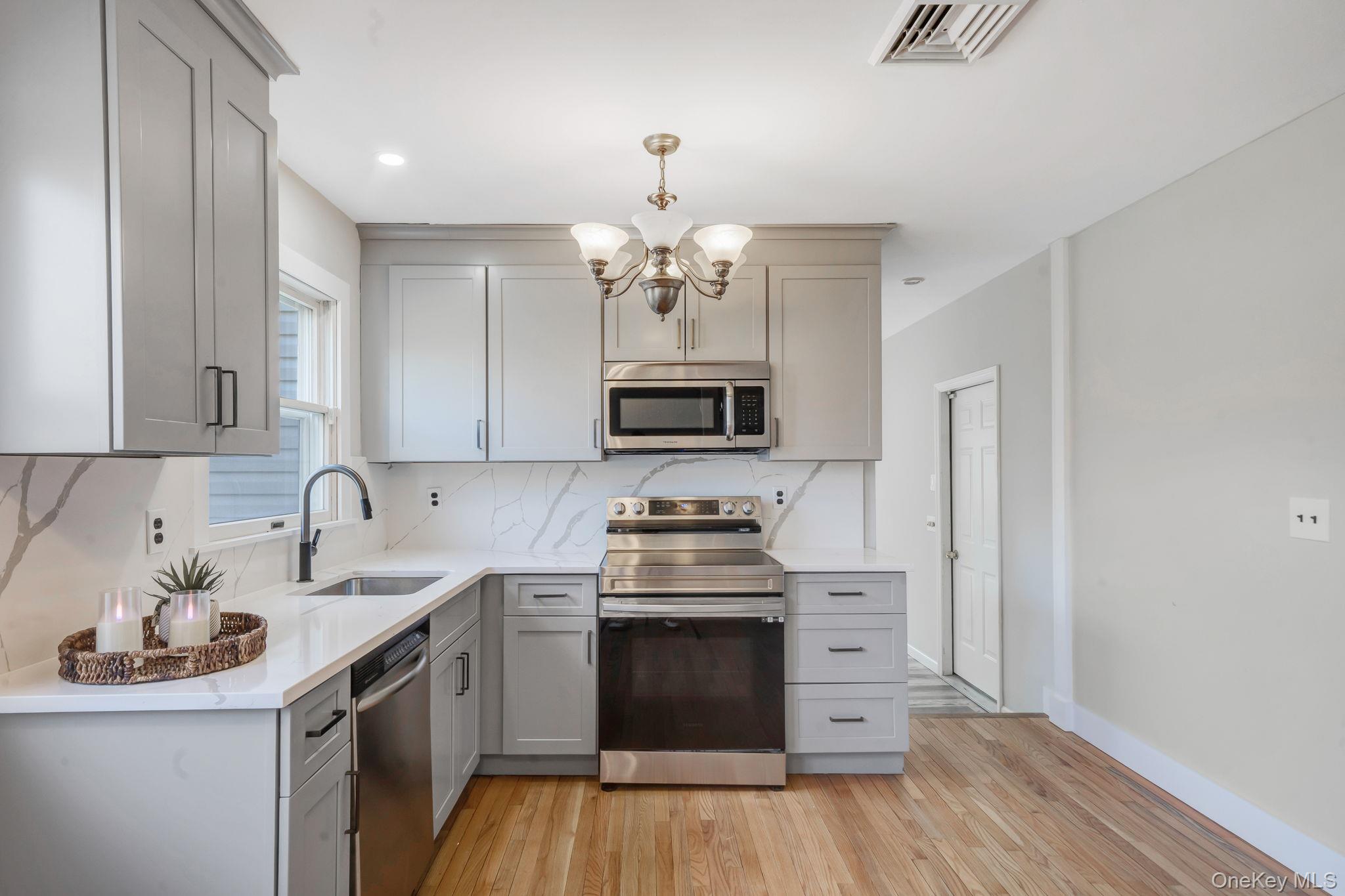71 Loop Drive Sayville, NY 11782 - Photo 11 of 45 a kitchen with stainless steel appliances a stove top oven and a sink