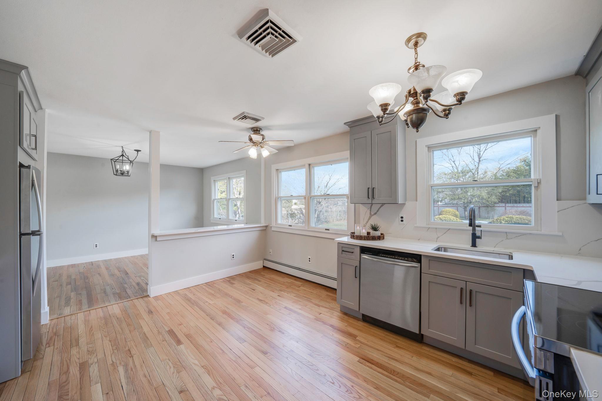 71 Loop Drive Sayville, NY 11782 - Photo 12 of 45 a large kitchen with a sink and dishwasher with wooden floor