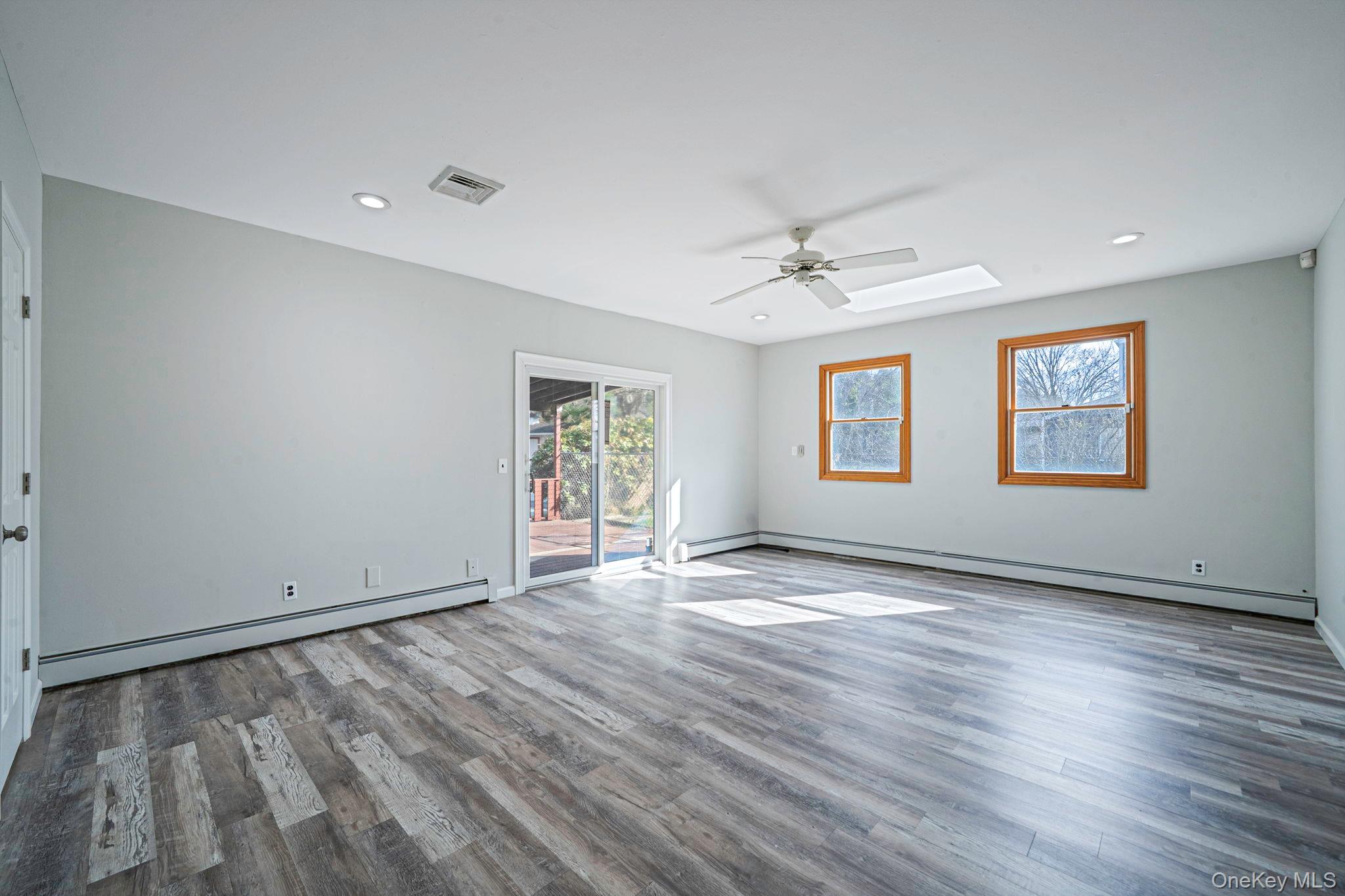 71 Loop Drive Sayville, NY 11782 - Photo 16 of 45 a view of an empty room with a window and wooden floor