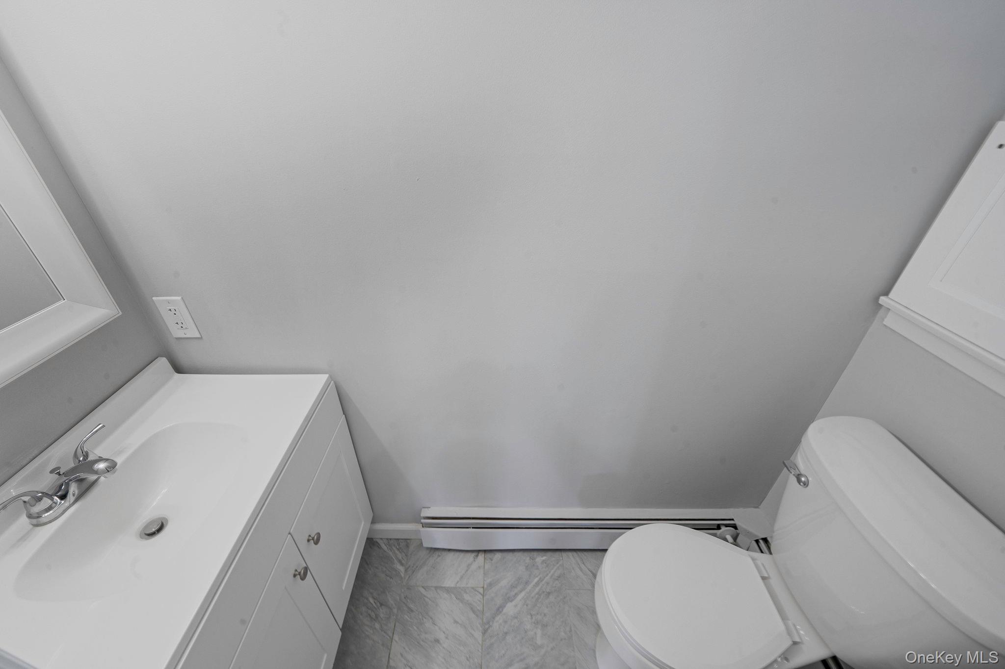 71 Loop Drive Sayville, NY 11782 - Photo 18 of 45 a white toilet sitting next to a bathroom sink