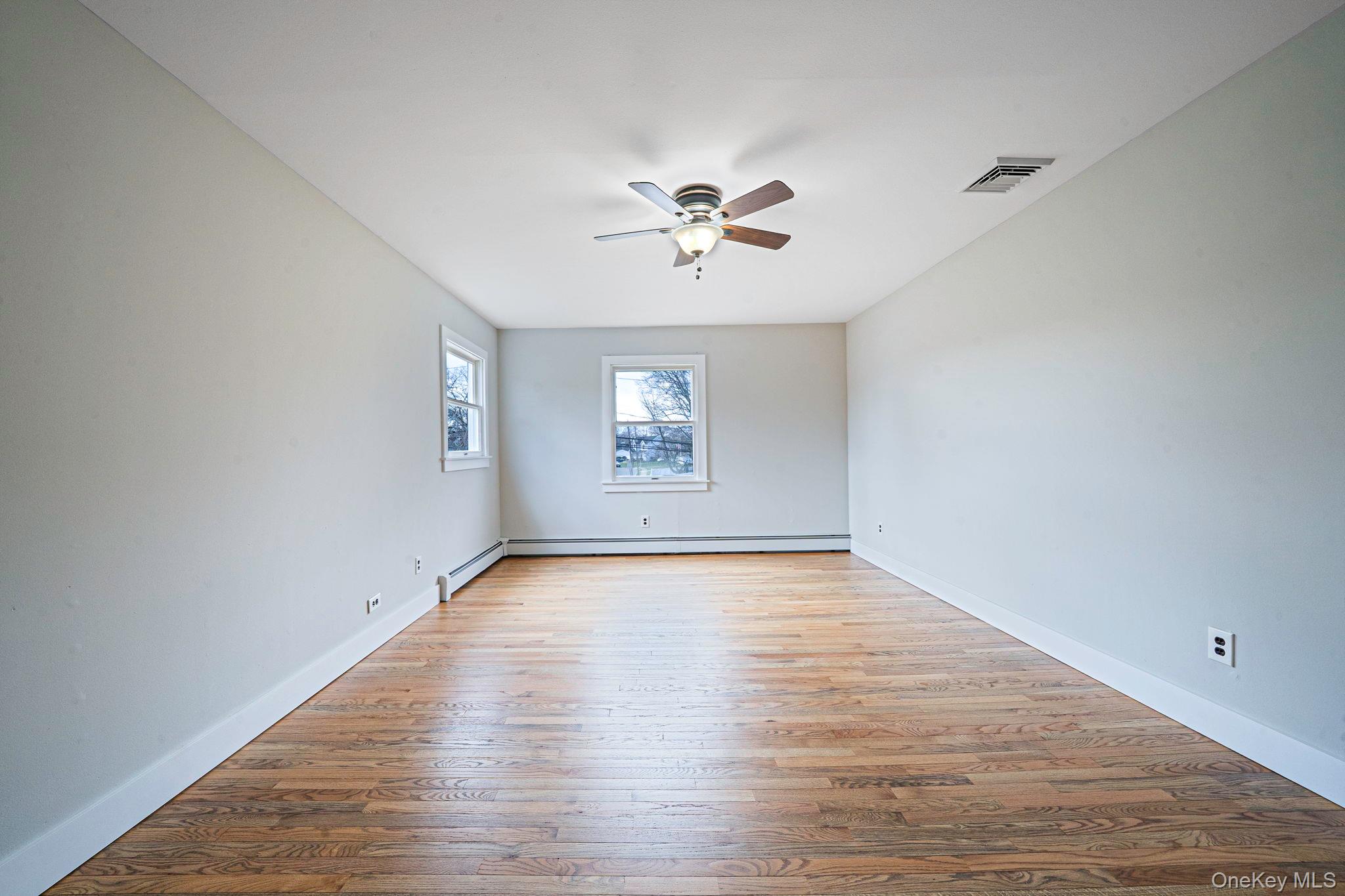 71 Loop Drive Sayville, NY 11782 - Photo 21 of 45 an empty room with wooden floor and windows