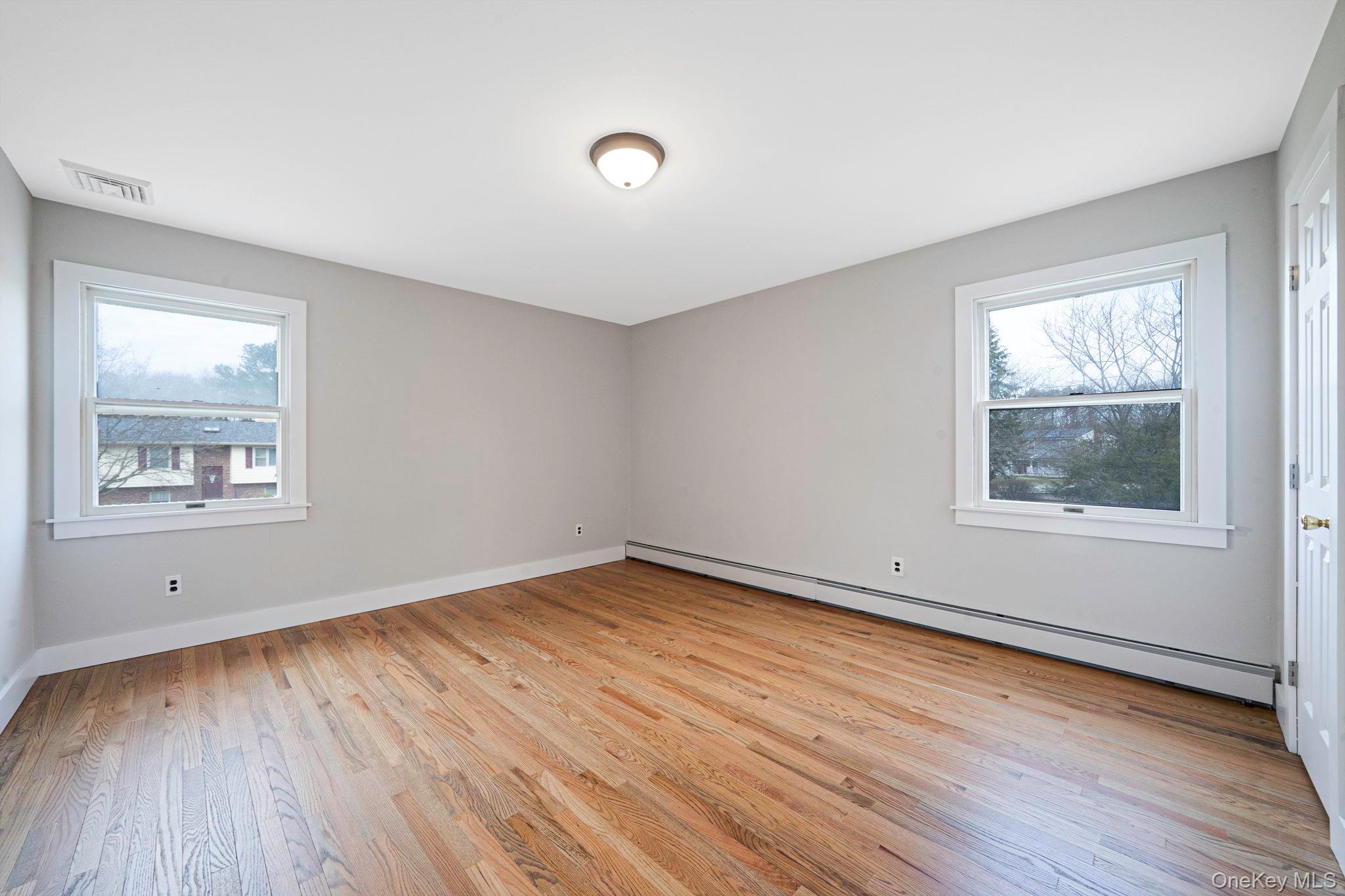 71 Loop Drive Sayville, NY 11782 - Photo 26 of 45 an empty room with wooden floor and windows