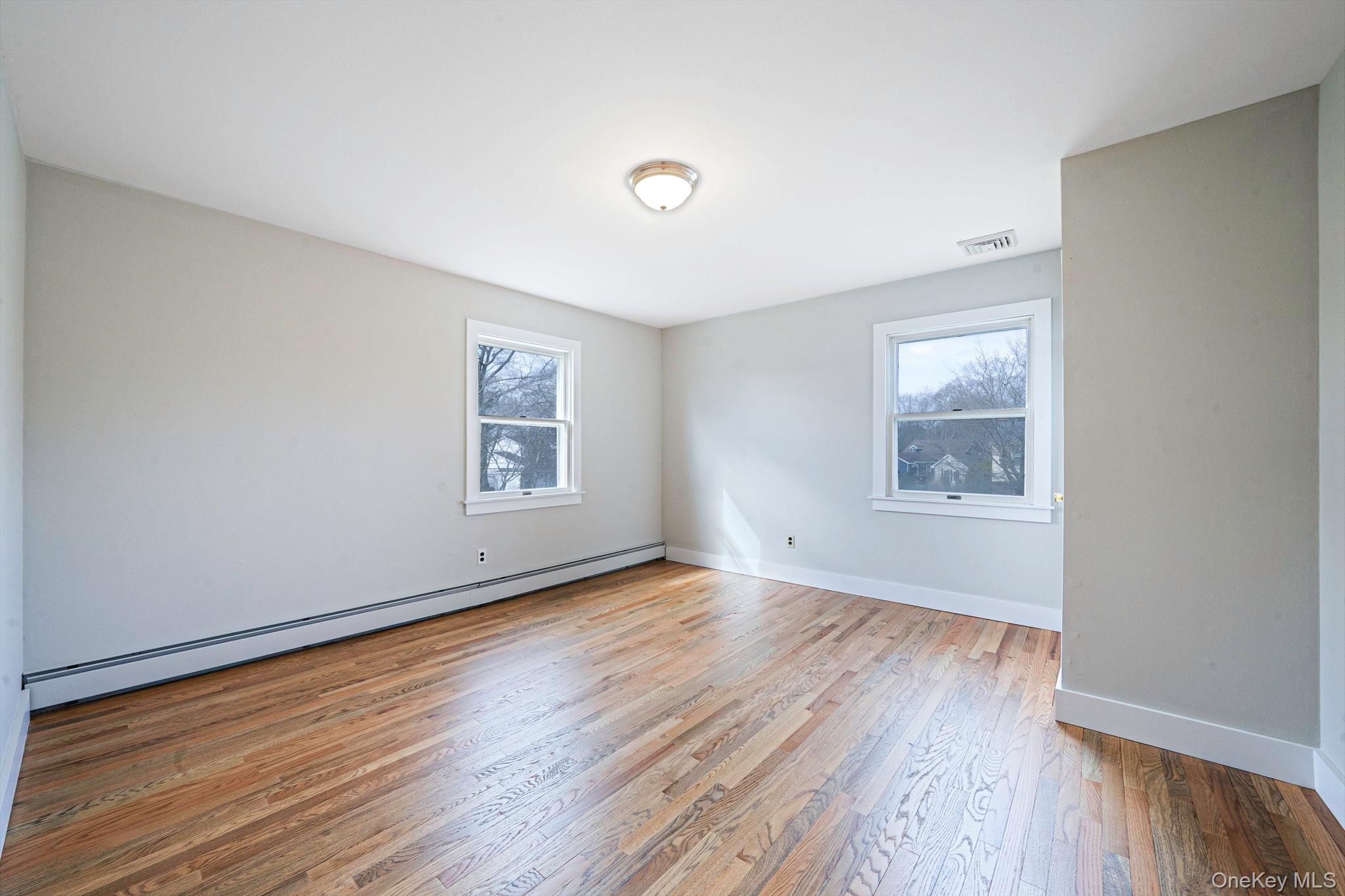 71 Loop Drive Sayville, NY 11782 - Photo 28 of 45 an empty room with wooden floor and windows