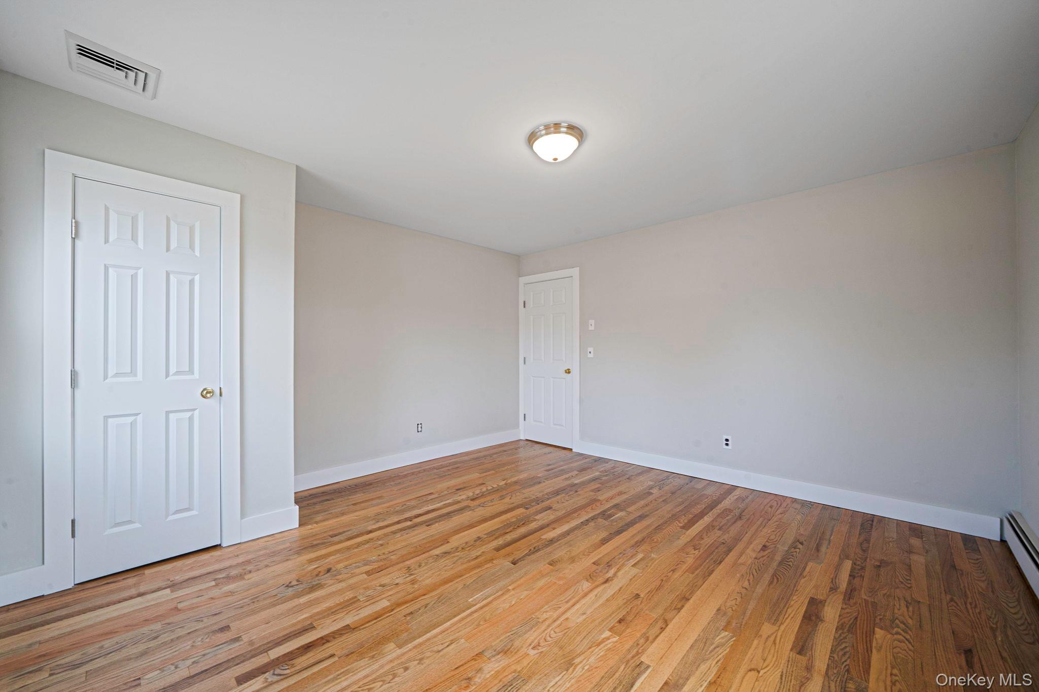 71 Loop Drive Sayville, NY 11782 - Photo 29 of 45 a view of room with wooden floor and white walls