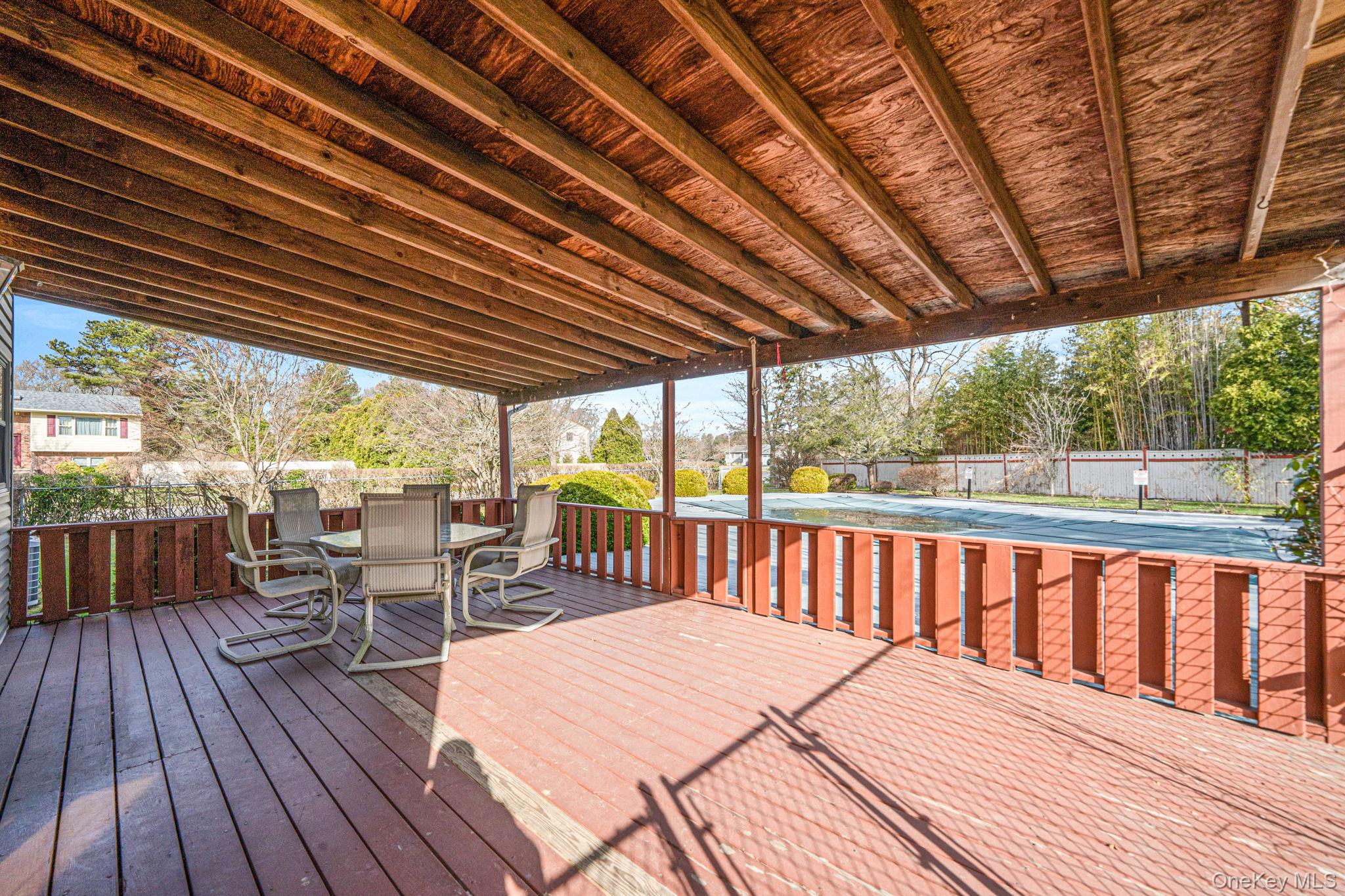 71 Loop Drive Sayville, NY 11782 - Photo 42 of 45 a view of a patio with wooden floor table and chairs