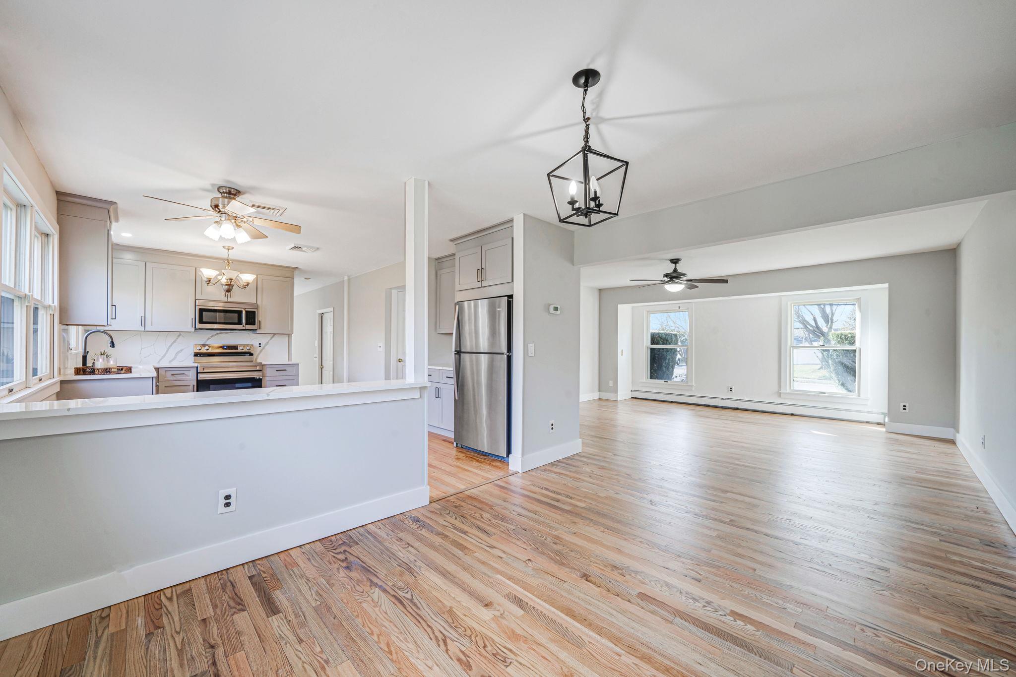 71 Loop Drive Sayville, NY 11782 - Photo 9 of 45 a view of a kitchen with a sink dishwasher a refrigerator and wooden floor