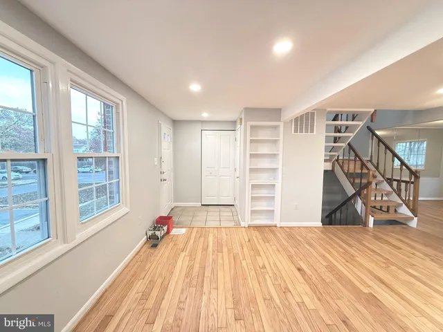 a view of empty room with wooden floor and windows