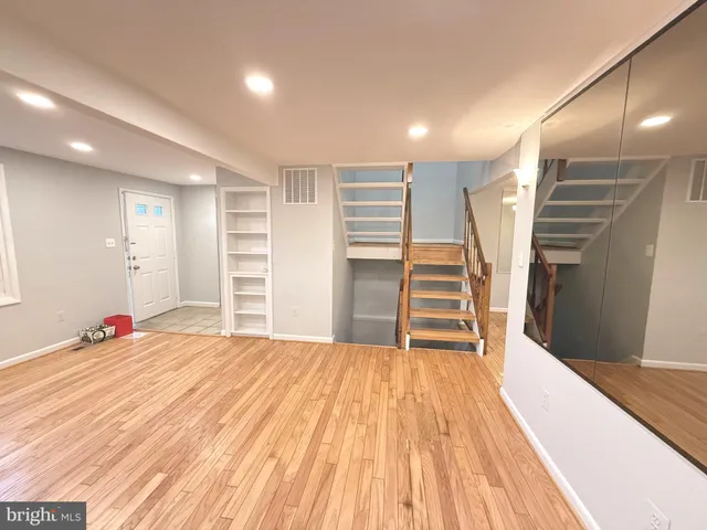 a view of a livingroom with wooden floor and stairs