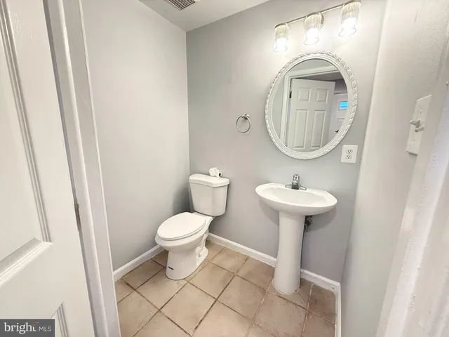 a bathroom with a sink toilet and a mirror