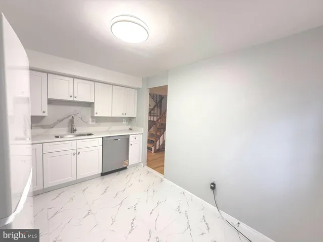 a kitchen with granite countertop white cabinets and white appliances