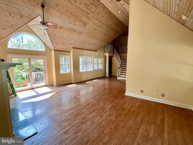 a kitchen with stainless steel appliances a stove a sink dishwasher a refrigerator white cabinets and wooden floor