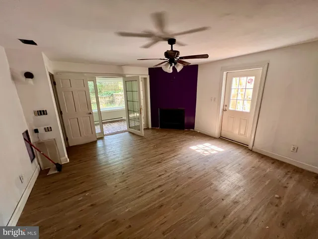 a view of empty room with window and wooden floor