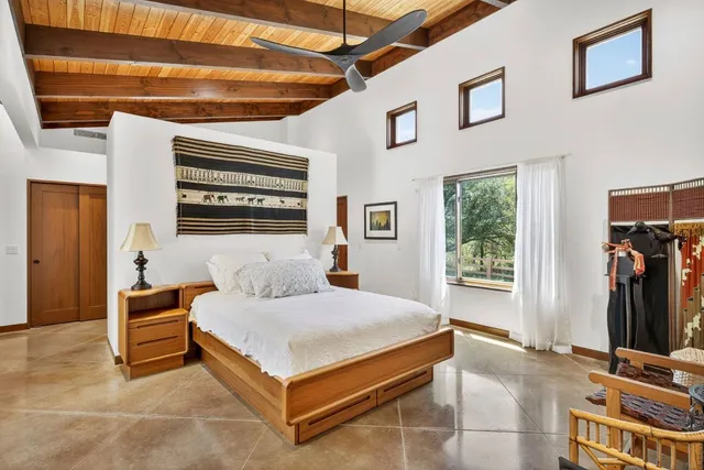 a bedroom with a bed and a flat tv screen on the wall