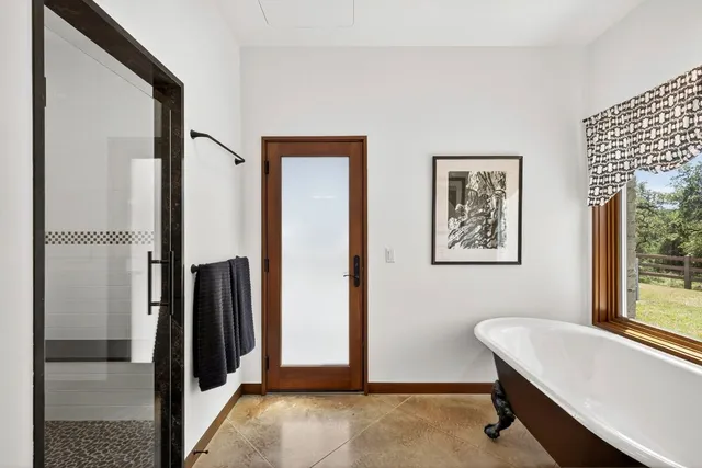 a bathroom with a tub and a view of bathroom