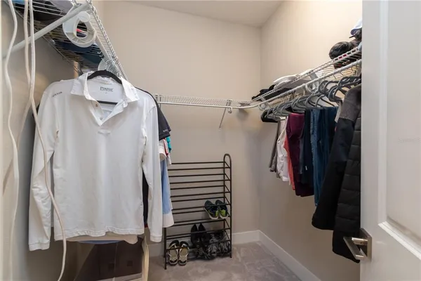 a view of walk in closet with clothes and shoes
