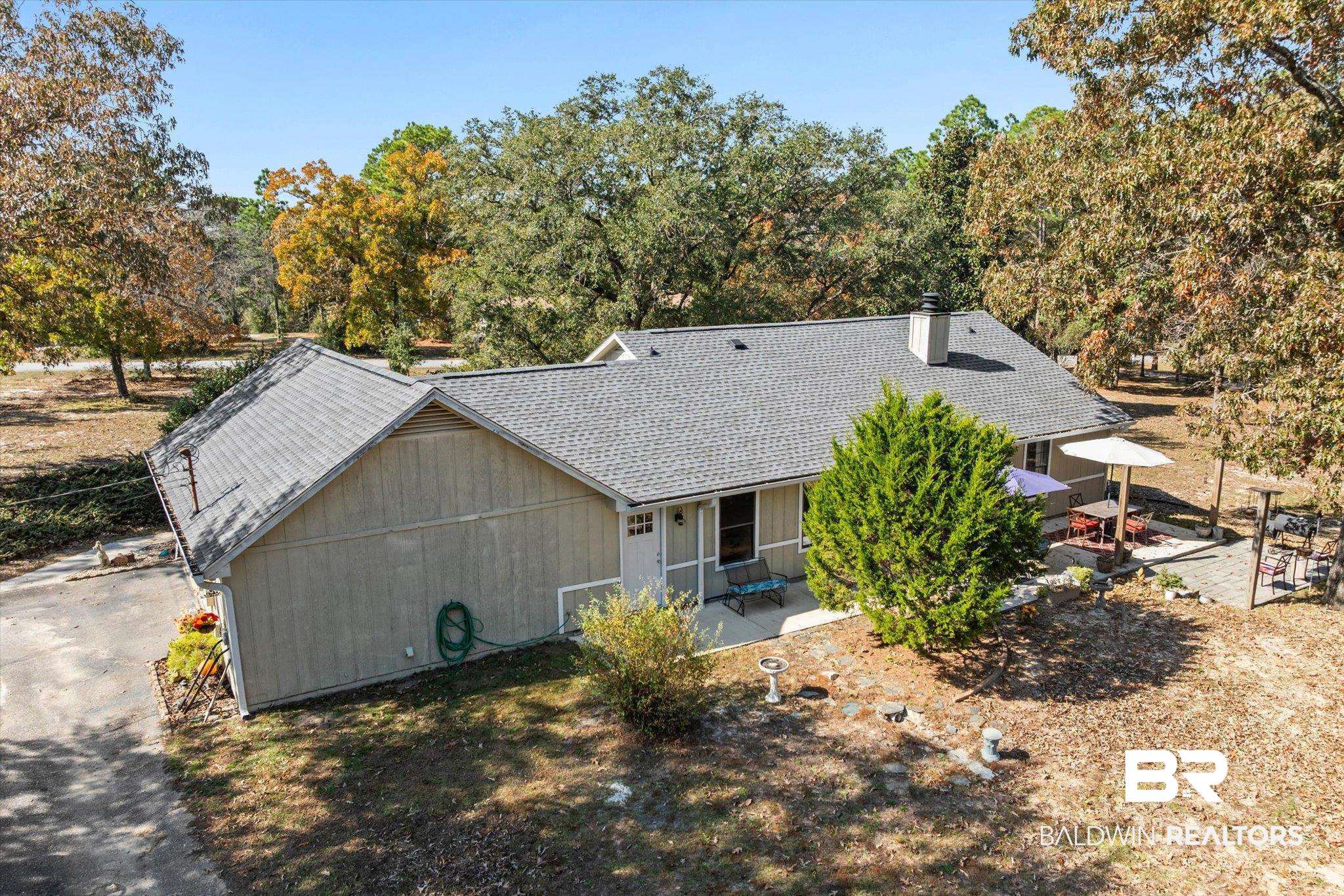 3846 Leslie Road Saraland, AL 36571 - Photo 22 of 40 View of front of house featuring a shingled roof, a chimney, and view of wooded area
