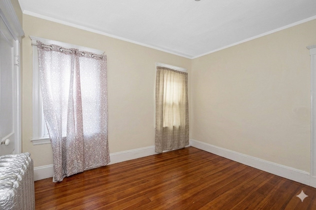 481 Lagrange Street Boston, MA 02132 - Photo 23 of 32 a view of an empty room with wooden floor and a window