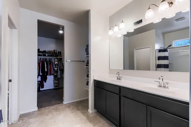 a spacious bedroom with a bed and a ceiling fan