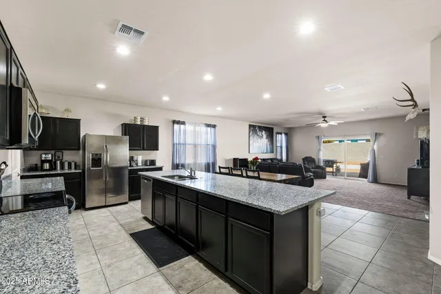 a living room with kitchen furniture and a flat screen tv