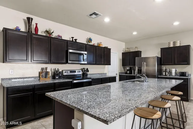 a kitchen with stainless steel appliances granite countertop a sink stove and refrigerator