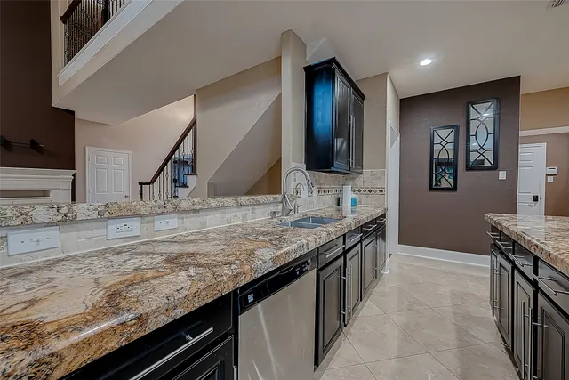 a kitchen with granite countertop a sink and a stove