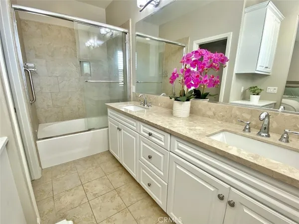 a bathroom with a granite countertop sink a shower and a mirror