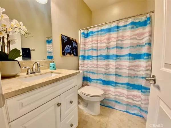 a bathroom with a sink a toilet and shower curtain