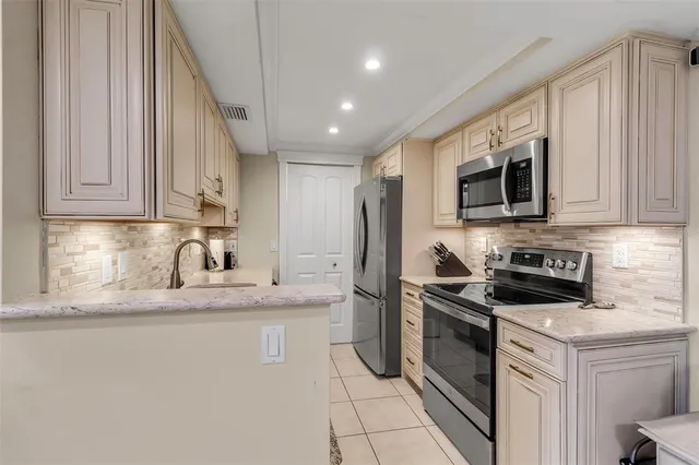 a kitchen with stainless steel appliances granite countertop a stove a sink and a microwave
