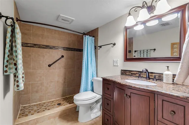 a bathroom with a granite countertop sink toilet and shower