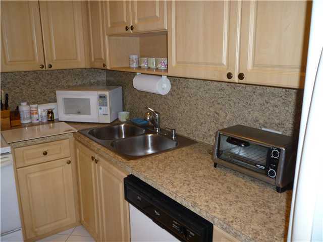 4345 Trevi Court, Unit 208 Lake Worth, FL 33467 - Photo 3 of 20 a kitchen with a sink stove and cabinets