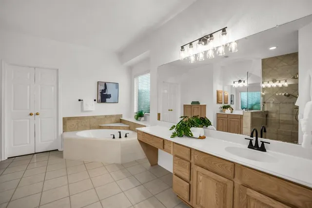 a spacious bathroom with a tub sink and mirror