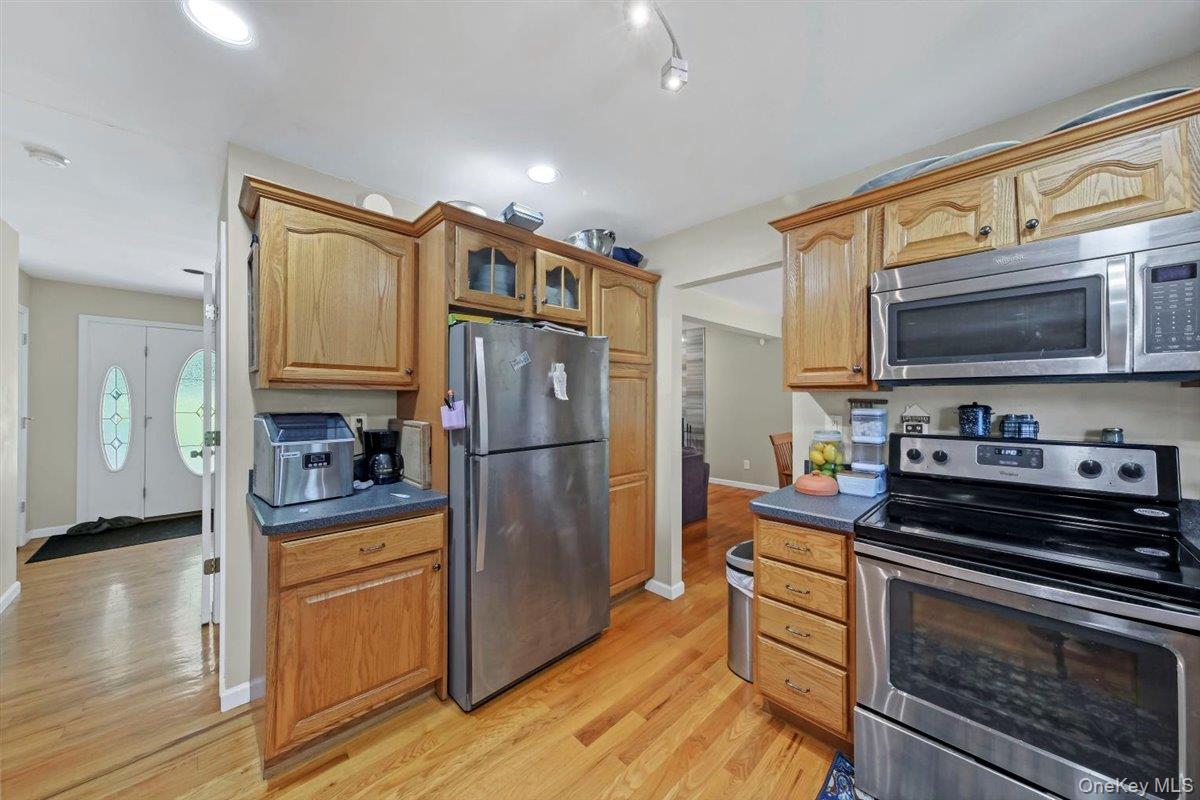 220 Prospect Road Monroe, NY 10950 - Photo 16 of 42 Kitchen featuring appliances with stainless steel finishes, dark countertops, light wood-style flooring, glass insert cabinets, and recessed lighting