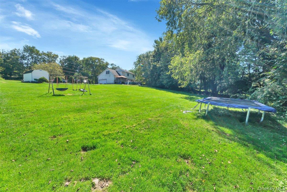 220 Prospect Road Monroe, NY 10950 - Photo 39 of 42 View of green lawn featuring a trampoline and view of wooded area