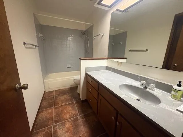 a bathroom with a granite countertop sink a mirror and a bathtub