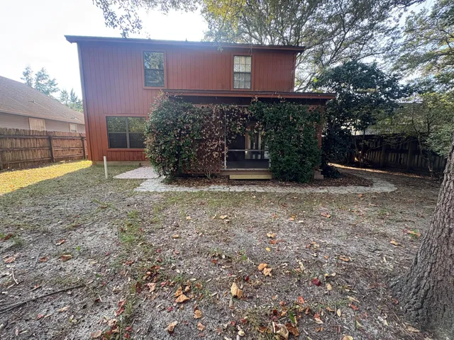 a view of a house with a yard and potted plants