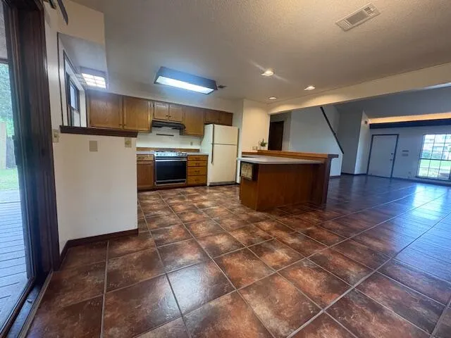 a view of kitchen with stainless steel appliances and cabinets