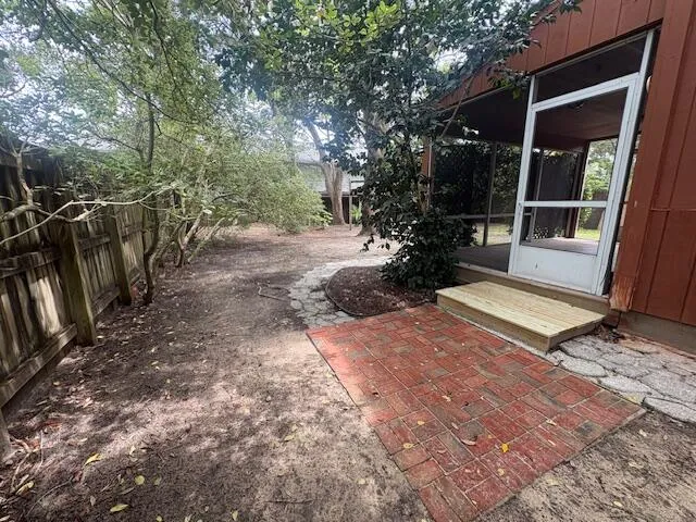 a view of a backyard with floor to ceiling window and wooden fence