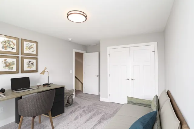 a view of a workspace with furniture and a window