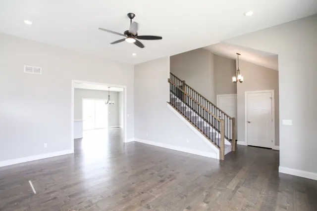 a view of a hallway with wooden floor and staircase