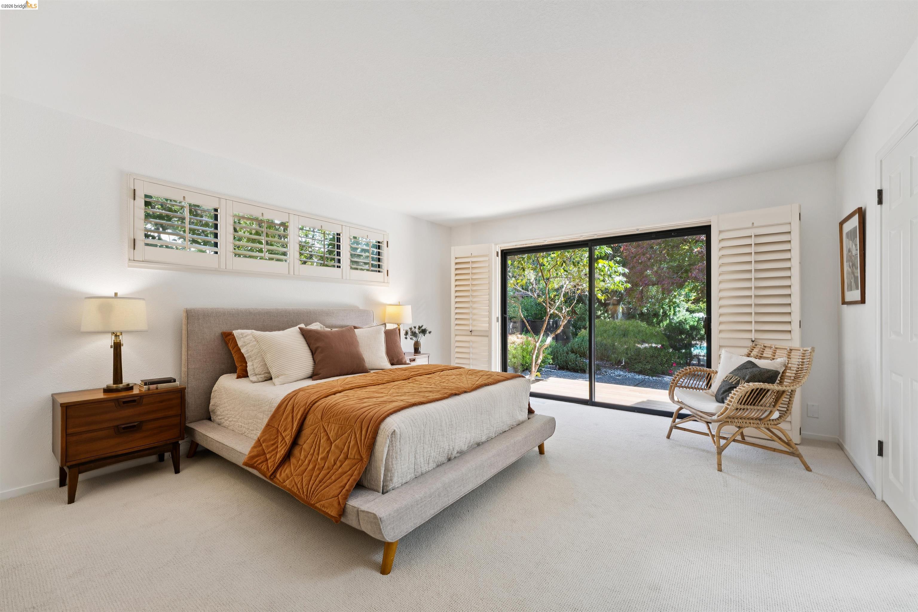 7 Jo Lin Court El Sobrante, CA 94803 - Photo 67 of 99 Bright bedroom featuring a large sliding glass door, white plantation shutters, and a wall of transom windows