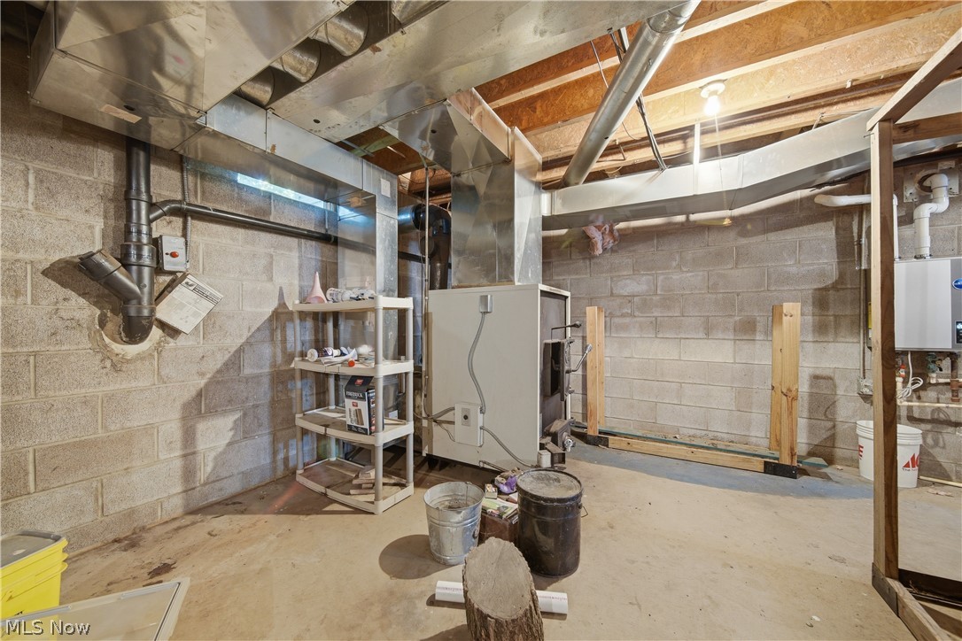12159 Lawndell Road Southwest Beach City, OH 44608 - Photo 33 of 49 Unfinished basement featuring concrete block walls, exposed wood ceiling joists, and a concrete floor